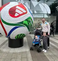 Rhys Hamilton with his family beside a large World Cup football statue
